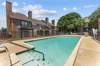 A swimming pool in a residential area with a black fence around it.